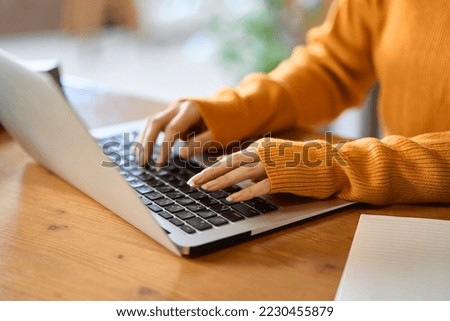 Asian woman's hand typing on a computer Royalty-Free Stock Photo #2230455879