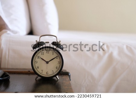 alarm clock on white bed. morning time.