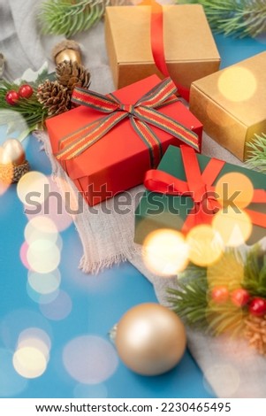 Christmas spruce with ball, gift and blurred shiny lights. Christmas or New Year Holiday atmosphere.