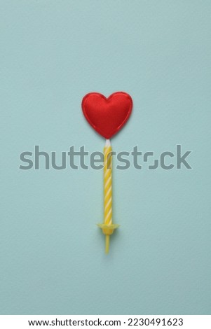 Candle with a heart on a blue background. Valentine's Day