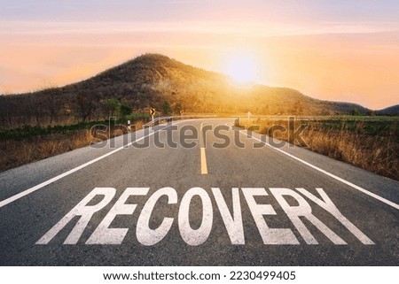  recovery written on highway road in the middle of empty asphalt road of asphalt road at sunset.Road to recovery with sunbream . Challenge with success concept and natural background idea. Royalty-Free Stock Photo #2230499405