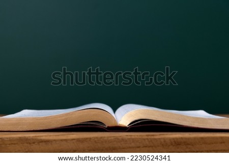 Open book in front of the blackboard