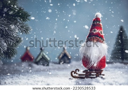 a Christmas gnome on a sled in the snow. New Year's, Christmas background with copy space