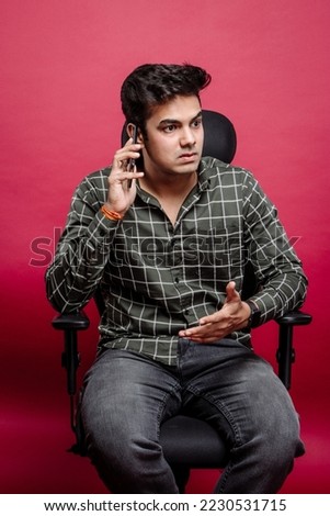 Stressed and frustrated arguing boss over the cellphone in the studio background. Angry man talking on the smartphone arguing or solving problems in a red background  studio.
 Royalty-Free Stock Photo #2230531715