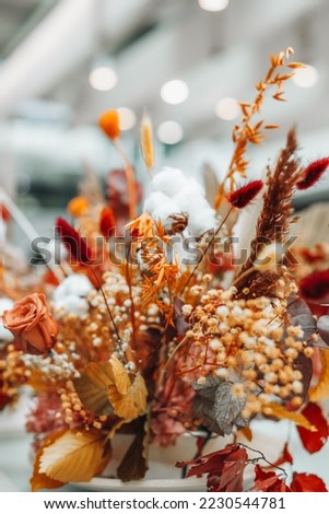 Autumn composition of dry flowers, roses and leaves. Orange bouquet