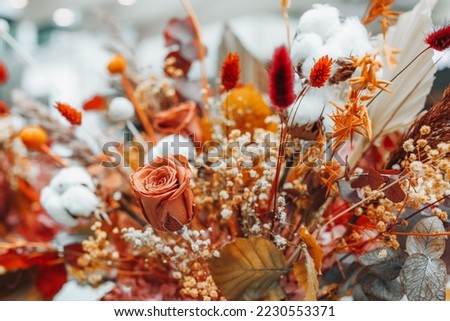 Composition of dried flowers, roses, cotton and leaves. Autumn cozy decor