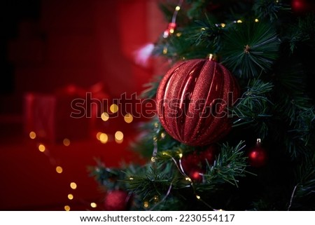 Decorated christmas tree, ornaments against a Defocused Lights and gifts box Background