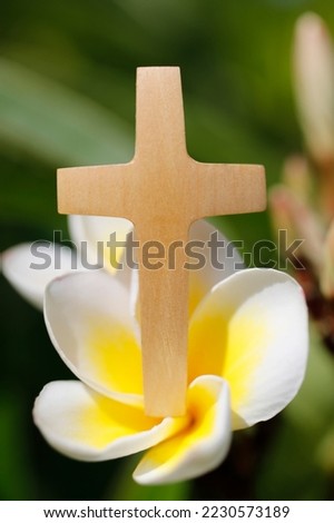 Close-up shot of christian cross on a fresh white magnolia flower. Faith and spirituality. 