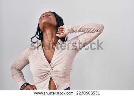 African woman with braids standing over white background stretching back, tired and relaxed, sleepy and yawning for early morning 