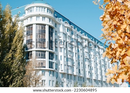 Beautiful residential apartment building in the old style exterior. Round corner, balconies and tiled roof on a sunny autumn day.