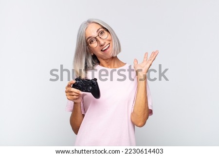 middle age woman feeling happy, surprised and cheerful, smiling with positive attitude, realizing a solution or idea. playing console concept