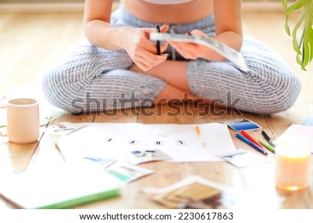 Young brunette woman creating her Feng Shui wish map using scissors. Dreams and wishes Royalty-Free Stock Photo #2230617863