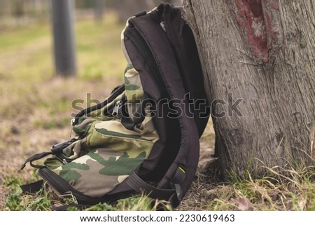 camping bag leaning against tree
