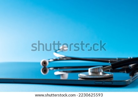 Composition of stethoscope with tablet on blue background, with copy space. Medical services, healthcare and health awareness concept.