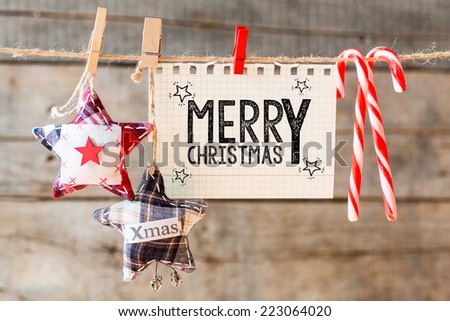 Merry christmas inscription. Merry Christmas inscription on checkered paper attach to rope  Royalty-Free Stock Photo #223064020