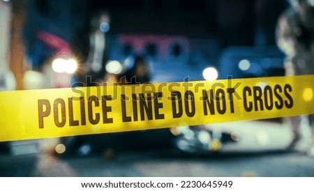 Yellow Tape Showing Text "Police Line Do Not Cross" Restricting a Crime Scene Area At Night. Close Up Aesthetic Shot with Bokeh Effect and Flickering Lights. Criminal on the Loose Strikes Again Royalty-Free Stock Photo #2230645949