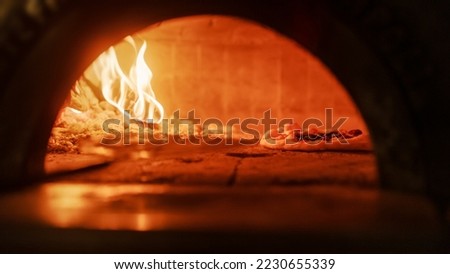 In Restaurant Pizza Peel Transferring Pizza into Wood Fire Stone Oven. Traditional Cooking, Italian Family Recipe. Authentic Pizzeria with Delicious Organic Food. Cinematic No People Shot