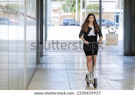 female manager with her scooter in modern urban environment