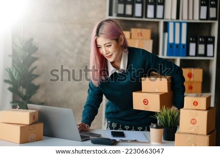  Woman hand using a laptop, smartphone and tablet and writing notebook at the office of her business online shopping. In home 