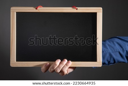 Man showing empty school blackboard.