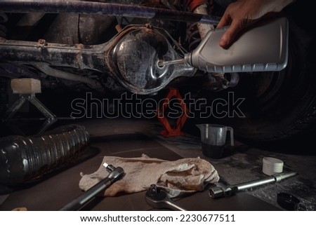 Changing the oil in the front differential of an off-road vehicle, truck with four-wheel drive. Car service. Tools and spare parts. Royalty-Free Stock Photo #2230677511