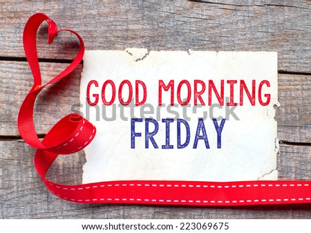 Good Morning Friday. White card with text Good Morning Friday on wooden table, with red ribbon 