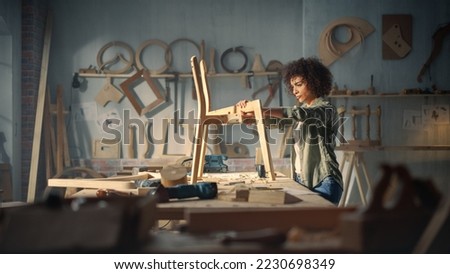 Female Artisan Furniture Designer Marking Out Dimensions on a Blueprint and Starting to Assemble a Wooden Chair. Multiethnic Black Carpenter Working in a Studio Royalty-Free Stock Photo #2230698349
