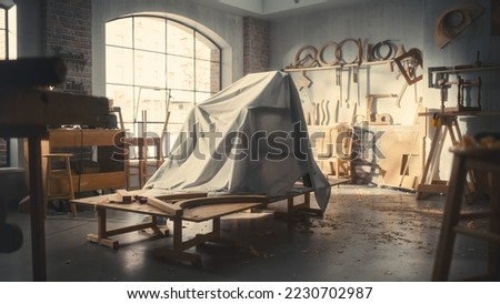 Establishing Shot: Designer Chair Hidden Under a Veil Before Official Presentation in Carpentry Workshop. Shot of a Stylish Armchair Under Cloth Cover. Royalty-Free Stock Photo #2230702987