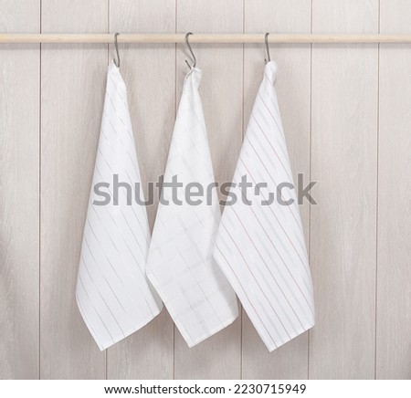 Kitchen towels hanging on wooden background Royalty-Free Stock Photo #2230715949