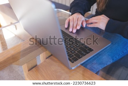 Closeup image of a woman working and touching on laptop computer touchpad