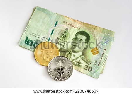 Physical Ethereum and Bitcoin over a twenty Thai Baht bill on white background. Cryptocurrency exchange, investment concept.