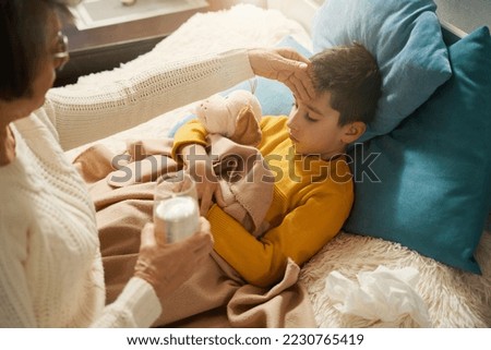 Woman caring of her child and giving him water Royalty-Free Stock Photo #2230765419