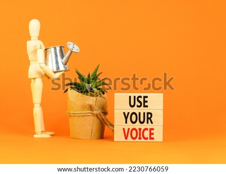 Use your voice symbol. Concept words Use your voice on wooden blocks on a beautiful orange table orange background. Businessman model. Business and use your voice concept. Copy space.