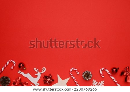 Christmas, winter composition. Layout on a red background of white Christmas toys, cones, balls, sweet canes.Flat lay, top view, copy space. Christmas, winter, new year concept.