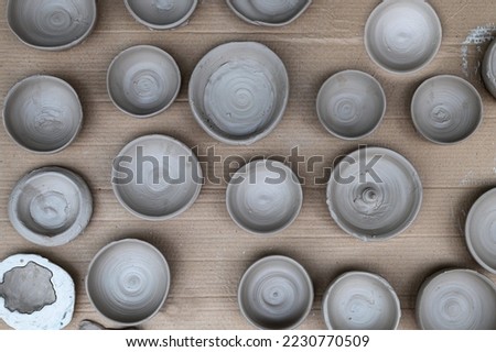 Top view at background of air drying handmade clay bowls. Royalty-Free Stock Photo #2230770509