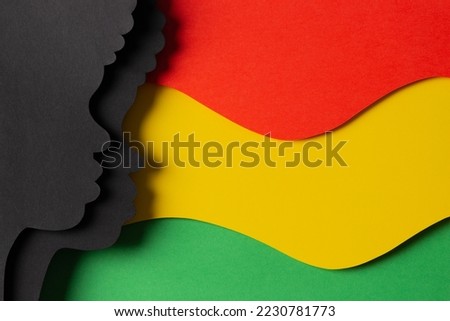 Black History Month color background. African Americans history celebration. Abstract geometric red, yellow, green color background with black paper cut people silhouette. Top view Royalty-Free Stock Photo #2230781773