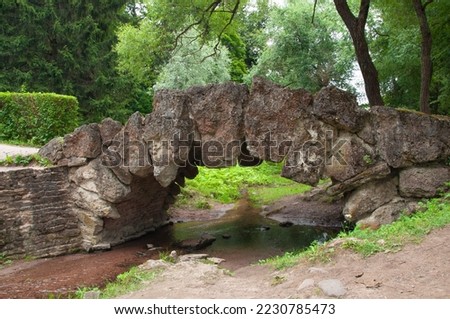 Vintage old unusual beautiful bridge made of large stones in the city park