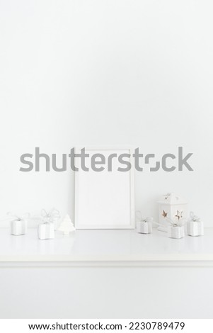 White frame with copy space and white gift boxes stand on a white table