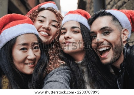 Happy diverse people having fun taking selfie picture outdoors during Christmas day - Holiday concept - Focus on gay transgender man face.