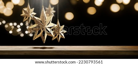 table with some sparkling stars on a defocused bokeh background of christmas lights