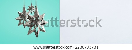 Christmas ornament hanging on a blue background behind a white banner - copy space
