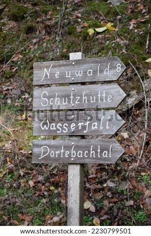 weathered wooden hiking sign to a waterfall