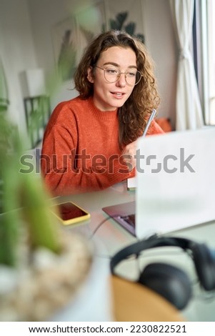 Young woman, female student or worker using laptop elearning or remote working at home office looking at computer watching webinar or having virtual meeting communicating by video call. Vertical. Royalty-Free Stock Photo #2230822521