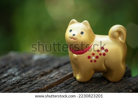 Old  golden dog bell ornament figurine good luck rich on nature background. Royalty-Free Stock Photo #2230823201