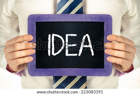 Idea, background with business word. Idea. Businessman holding board on the background with business word 