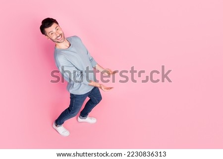 Full body photo high angle view of nice young guy carry heavy empty space dressed trendy blue garment isolated on pink color background