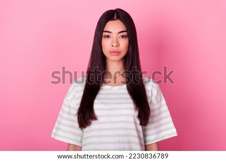 Photo of pretty calm young person look camera wear striped outfit isolated on pastel pink color background