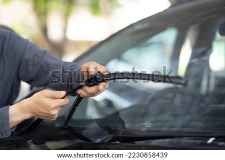 Technician replacing windshield wipers change car wiper blades Royalty-Free Stock Photo #2230858439