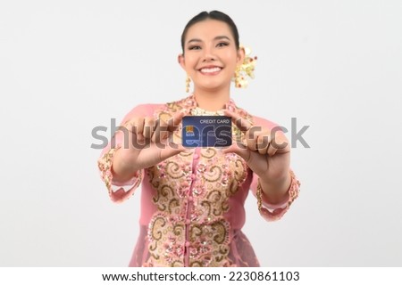 Selective focus, Young beautiful woman dress up in local culture in southern region show a credit card in hand and smile with cheerful on white background, copy space