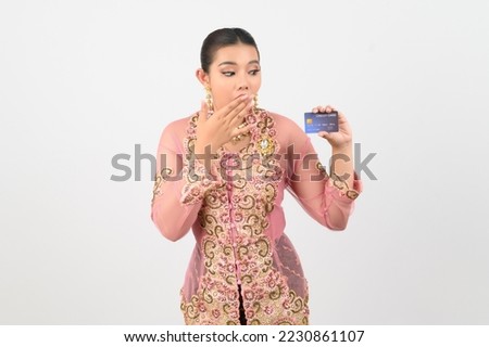 Young beautiful woman dress up in local culture in southern region show a credit card in hand and smile with cheerful on white background, copy space